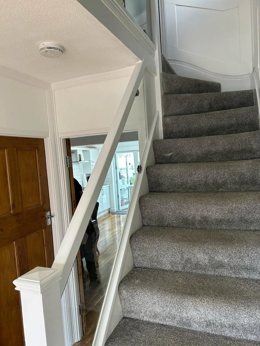 staircase-glass-balustrade-white-frame-grey-carpet-farnham-farnham-glass-balustrades Glass balustrade with white frame on staircase with grey carpet, Farnham installation